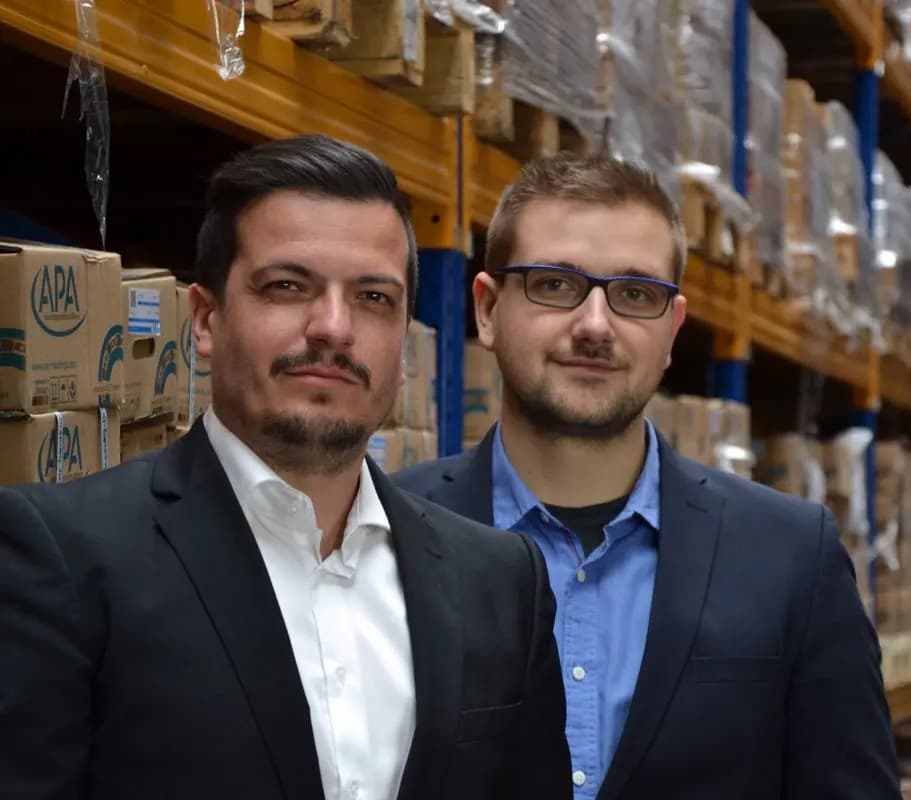 Zwei Mitarbeitende von BDT Bearing im Lager zwischen Palettenregalen